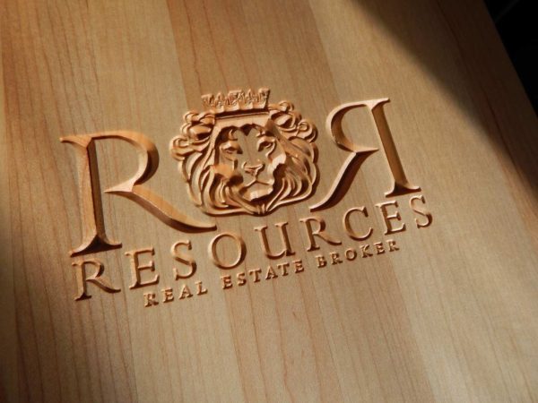 R & R resources with detailed lion logo carved into a cutting board