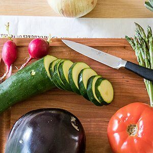 Various vegetables cut on a cutting board, including zucchini, radishes and eggplant